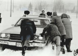 Ready, push! Even the police had a rough go of it when winter's meanest storm hit Metro last week