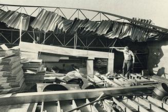 Wind rips roof off metro factory, A section fo roof 15 feet wide and 40 feet long peeled off by a gust of wind yesterday is inspected by foreman Doug (...)