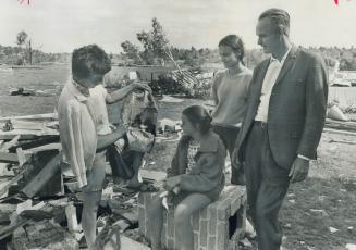 Salvaging what they can, Mrs. Vicki Kleber pulls on e of the family's possessions from the rubble of their storm-wrecked home at Lively, Ont., to show(...)