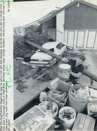 Picking up the pieces: Don Baggett loads his truck with the belongings he and his wife Rosemary were able to salvage after their roof was blown off