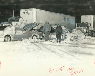 Ribbons of stalled cars and trucks out lined closed-down highways and roads in Wood-stock-Ingersoll area last night as drifts as high as 8 feet covere(...)