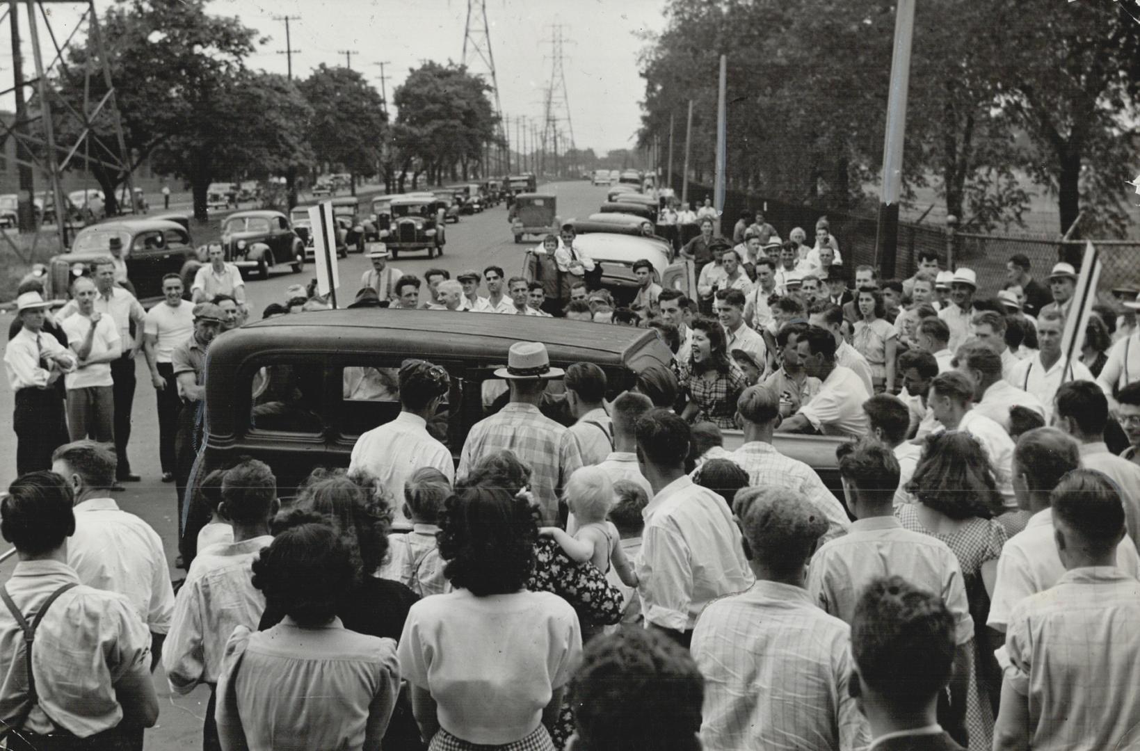 Pickets surround a car approaching the main gate of the sprawling Hamilton plant and bar its entry