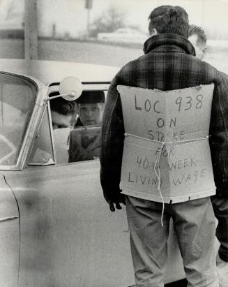 Poster-toting picket of the Teamsters Union is shown at his post outside Kingsway Transport depot today