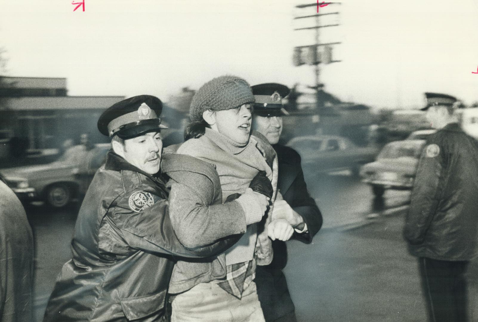 A picket is hauled off by police yesterday outside the Artistic Woodwork Co