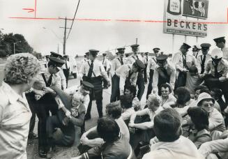 Policemen start to remove, some of the pickets who sat on the roadway this morning trying to block across to the Becker's milk plant on Warden Ave. Ab(...)