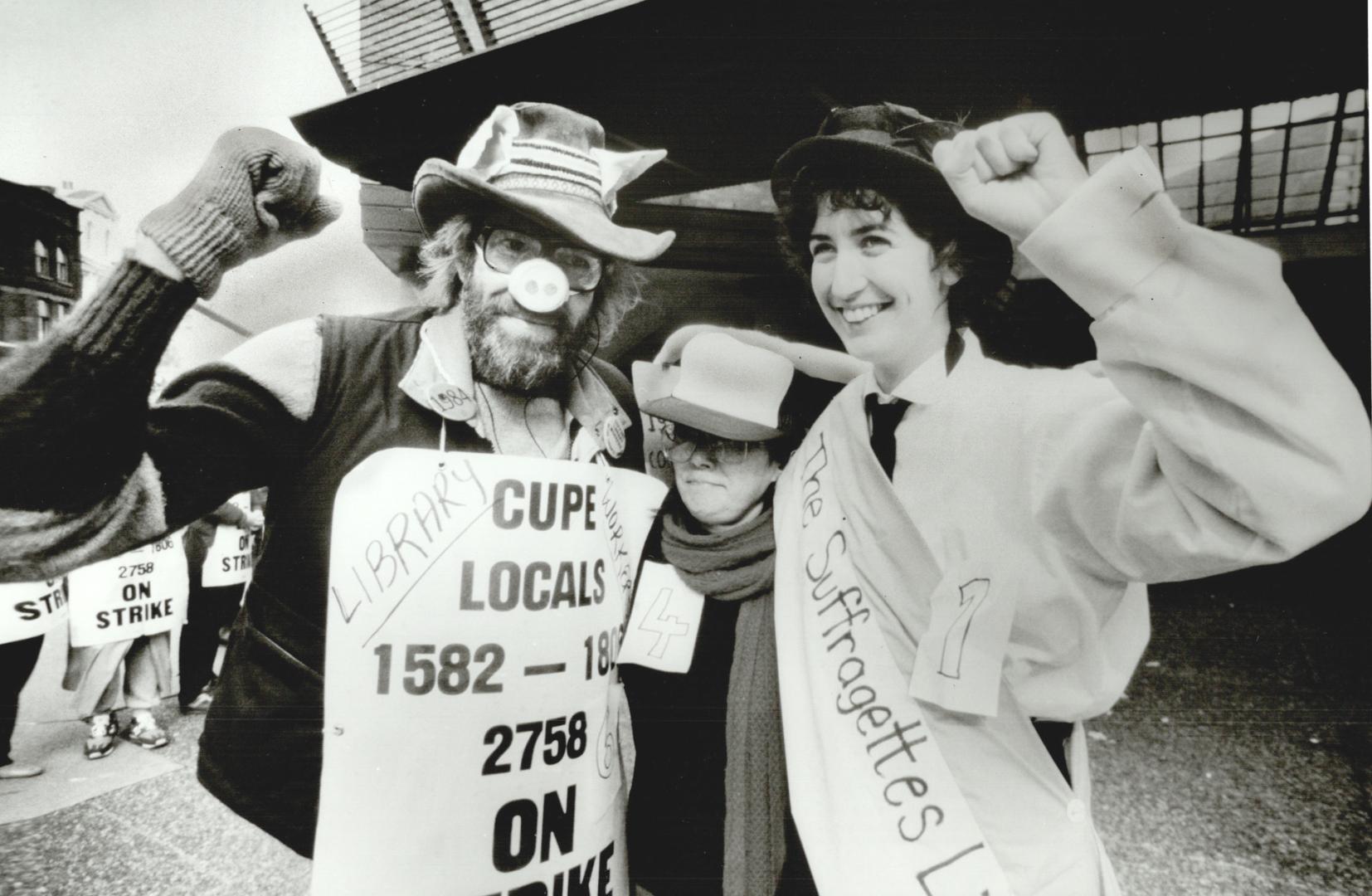 Some of 400 Metro library workers who are picketing to support their strike hold a costume party of sorts on the picket line at the central library 