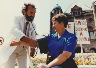 Doctors on strike front of Queens Park group call Central Toronto Position Pix of Dr Alan Kindler checking blood pressure Joan Segee