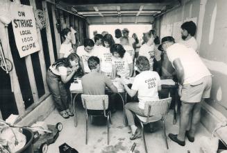 Day Three: Zoo manager Calvin White (right) feeds hippopotamus while about 40 strikers (above) meet at makeshift headquarters