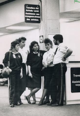 Striking security: Union representative John Miller, right, talks to four security guards who took part in a wildcat protest by about 80 guards at Pearson yesterday