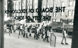 While striking teachers picket outside the Education Centre on College St