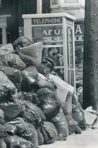 Rosan Randazzo makes a telephone call from a booth at Grace and Harbord Sts