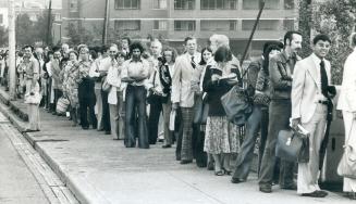 Commuters - many of them new - line up at the GO Transit station on Main St