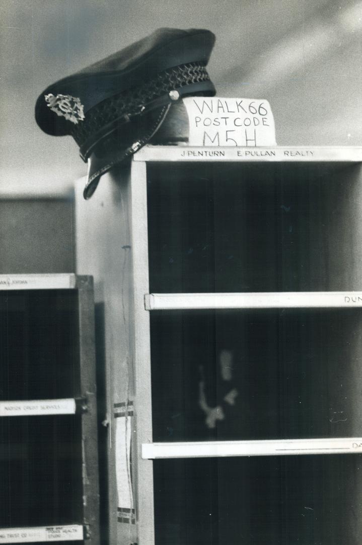 Laid-off Postie's hat, hung on empty sorting boxes, symbolized strike and inflation woes