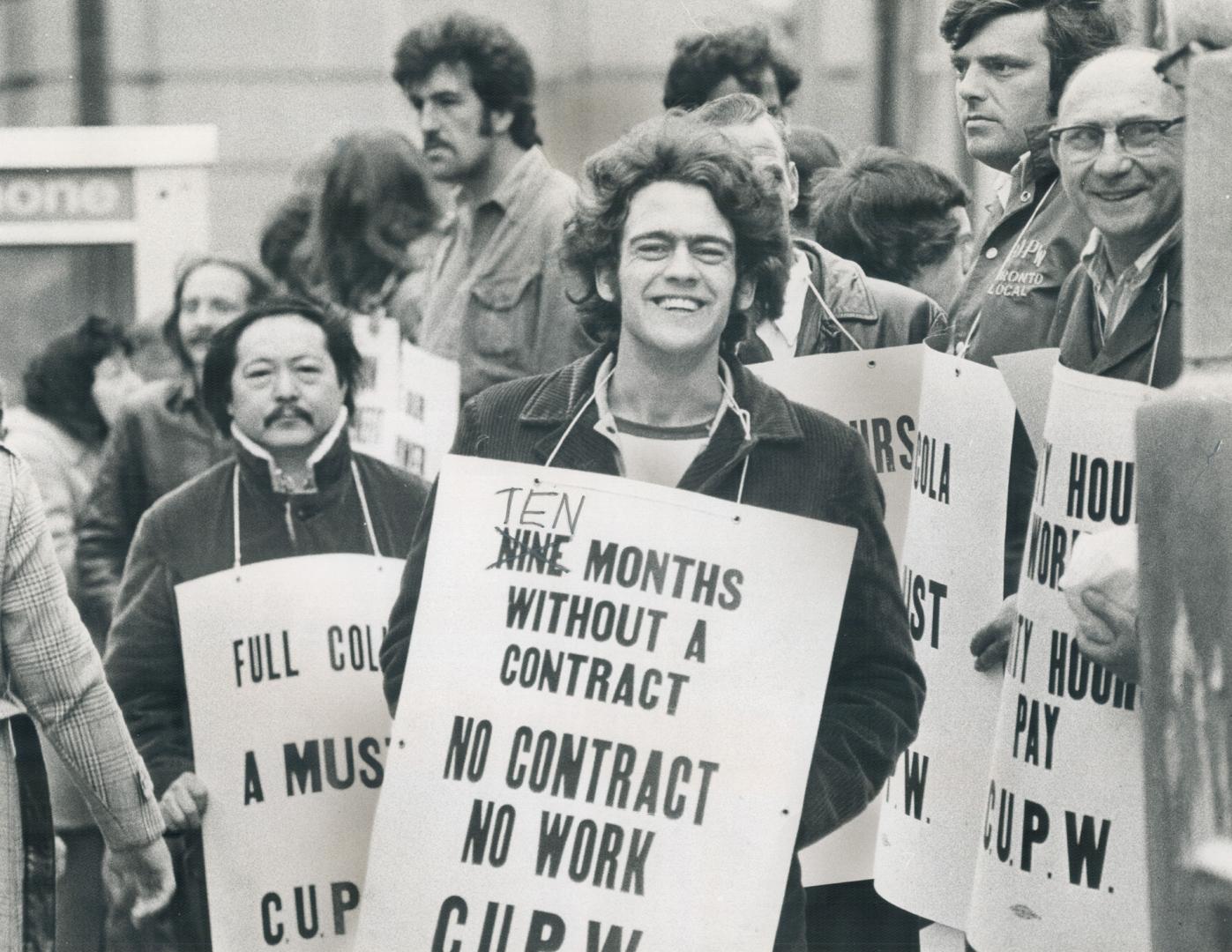 Striking postal workers picket outside Terminal A, at Bay and Front Sts