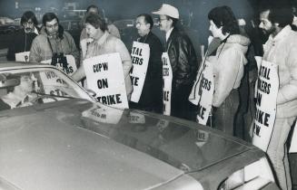 Striking postal workers, above, stop car on picket line