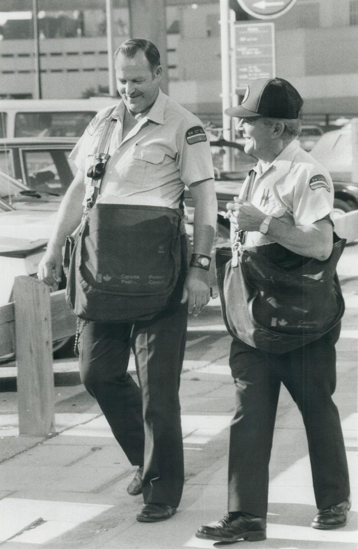 Two letter carriers leave the Bay St