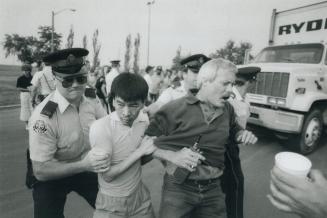 Metro policemen hustle striking letter carriers out of a truck's path as the vehicle enters the Eastern Ave