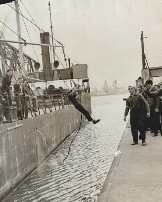 Strike-Breaker gets off the Kingdoc at Welland by the Tarzan method, swinging ashore by a rope to join others of his group who lined up with strikers.(...)