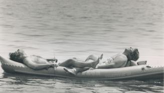 A couple off Cherry Beach try to beat the steamy heat wave that made yesterday's temperatures feel like 42 Celsius, about 108F