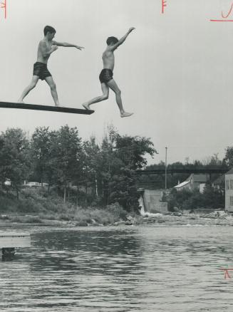 Ontario Holiday: Almaguin, Hesitating diver gets an assist from a friend as two boys have fun in the Magnetawan River at Burks Falls