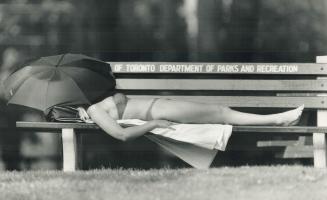 Gimme shelter: While Toronto broils under 31C (88F) heat yesterday, this young woman finds some relief beneath the shady trees of Kew Gardens on the lakeshore