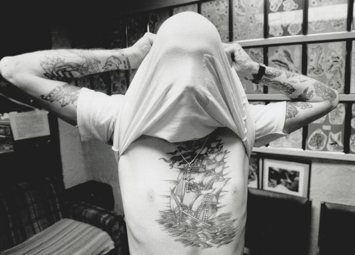 Brian Cotterell's not camera shy, he's just showing off some of the 53 designs he has tattooed on his body