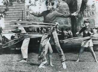 Leaping in the air, 8-year-old Brian Blattberg doesn't miss a swivel as he twirls two hula hoops at the same time