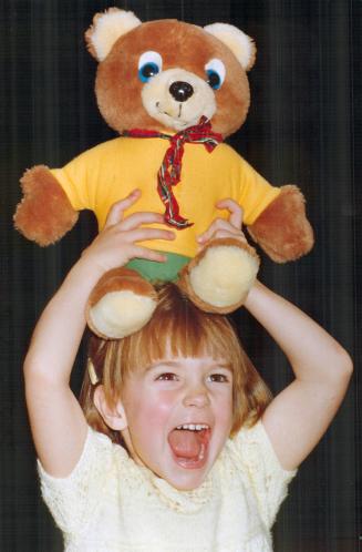 Laura Burns, 3, and her teddy bear join the fun yesterday at the Teddy Bear's Christmas Party, held to aid the Orthopaedic an Arthritic Hospital. Adul(...)