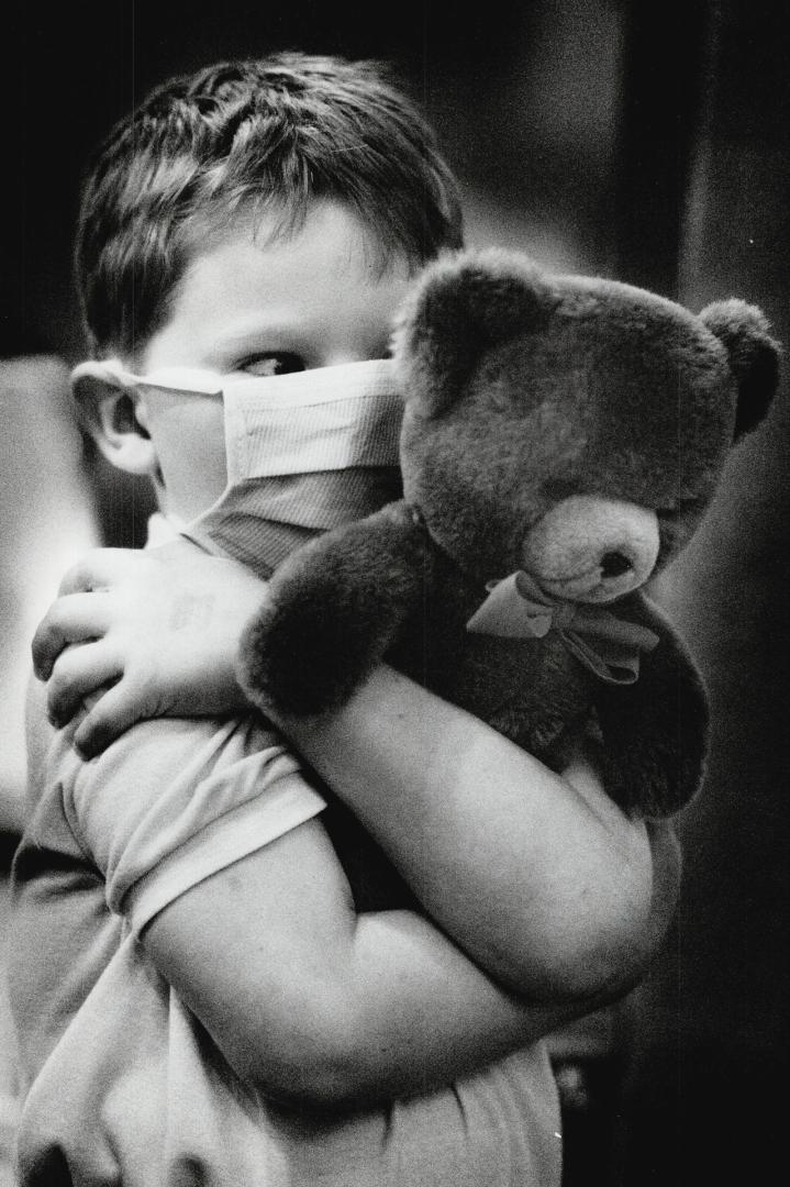 A bear hug for teddy, Walter Bax, 6, administers hug therapy to a friend following surgery at yesterday's Teddy Bear Picnic at Cullen Country Barns