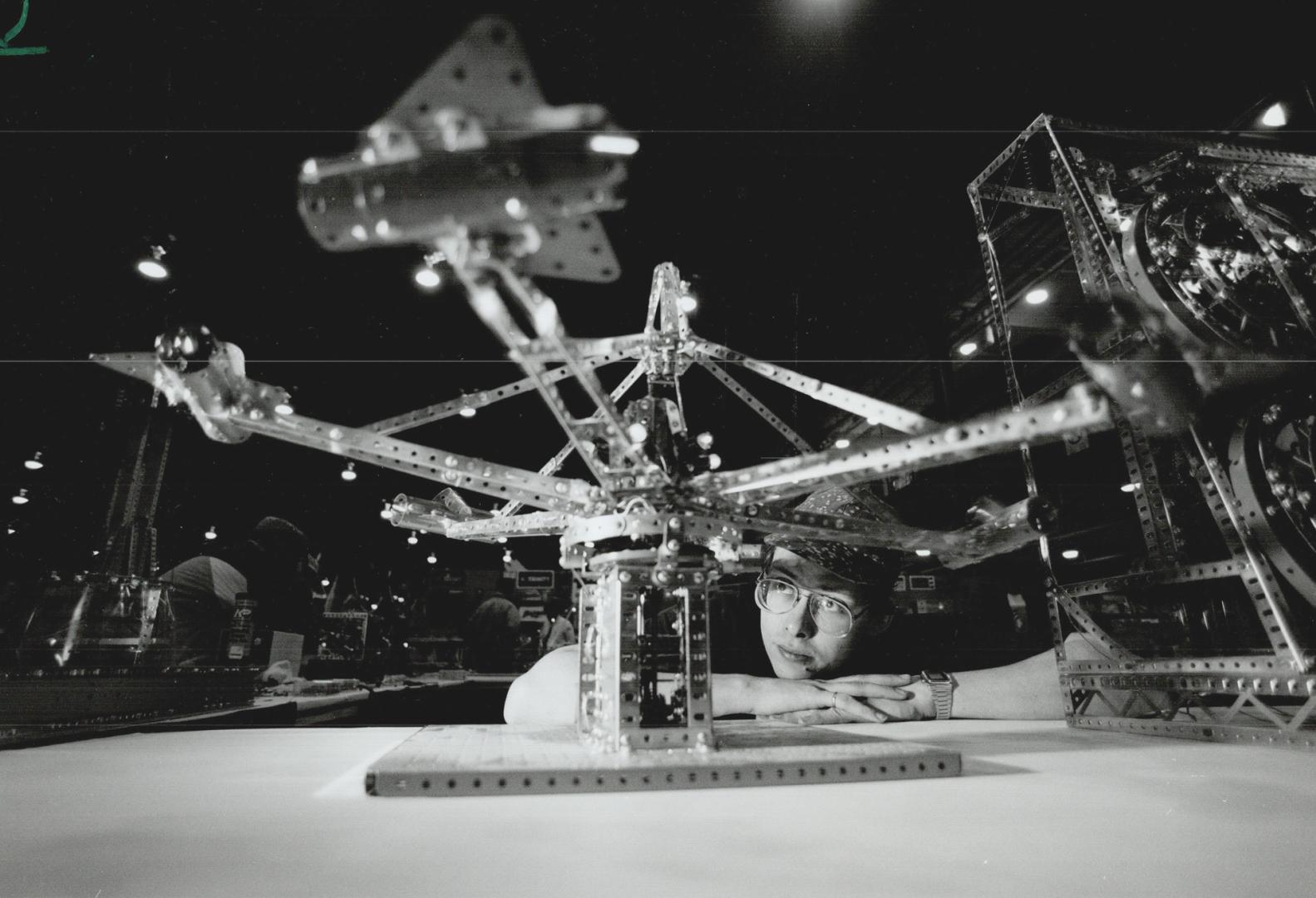 Great flying jets!, Colin Hinz Orillia, a member of the Canadian Meccano Man's club, closely watches one of the mechanized creations on display yesterday during a hobby show at Exhibition Place