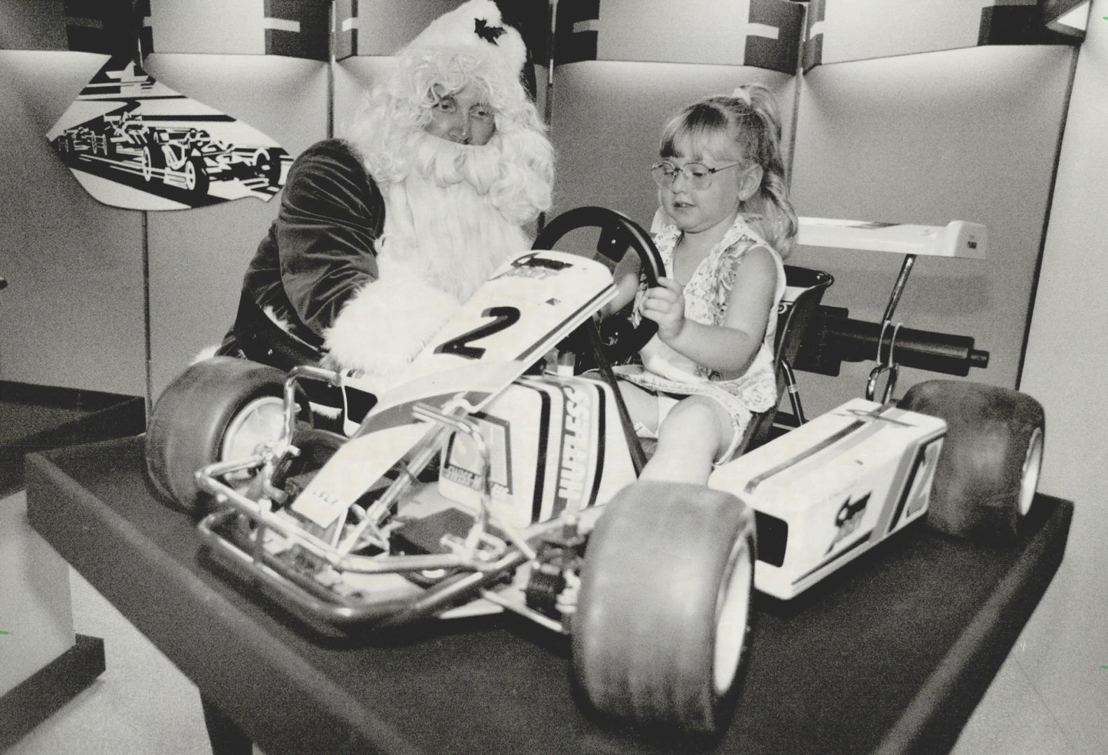 Santa's helper: Maxine Goldman, 4, and Santa inspect a snazzy standby at yesterday's unvelling of Irwin Toys' new line of high-tech Christmas goodies