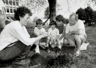 A tree for tomorrow, Metro worker Jody Rosenblatt shows, from left, 8-year-old Andrew and Stephen Yuie, 5, Marie Macinally and Joe Holmes how to plant(...)