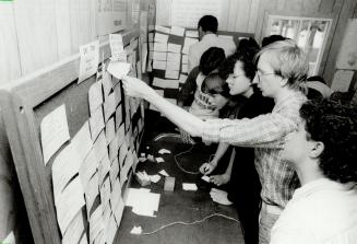 Lots of jobs: Jobseekers scan the help-wanted board yesterday in the Canada Employment Centre set up at the Canadian National Exhibition