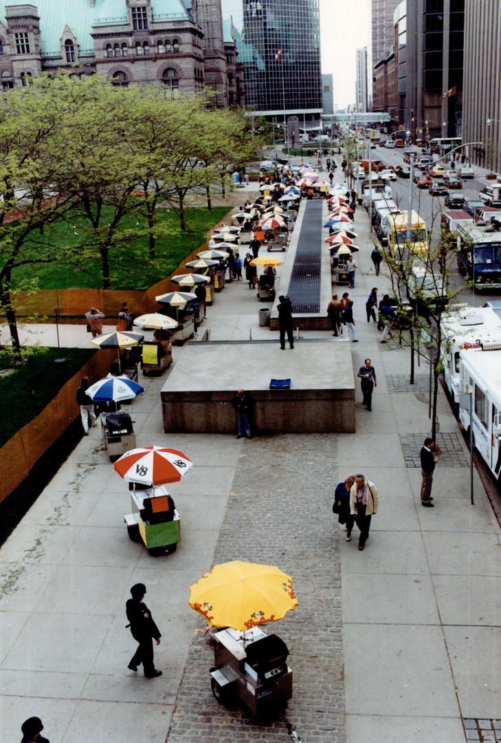 Umbrellas unite: About 150 protesters push hot dog carts and drive chip wagons up Queen St