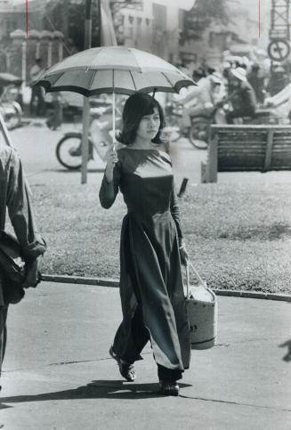 Young woman on shopping trip, Umbrella protects her from the hot sun