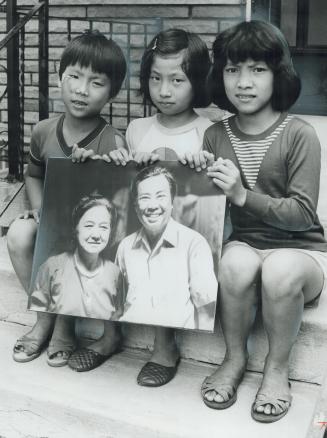 Evan Dien, 6, left, and sisters Ellen, 7, and Lena, 8, hold picture of grandparents