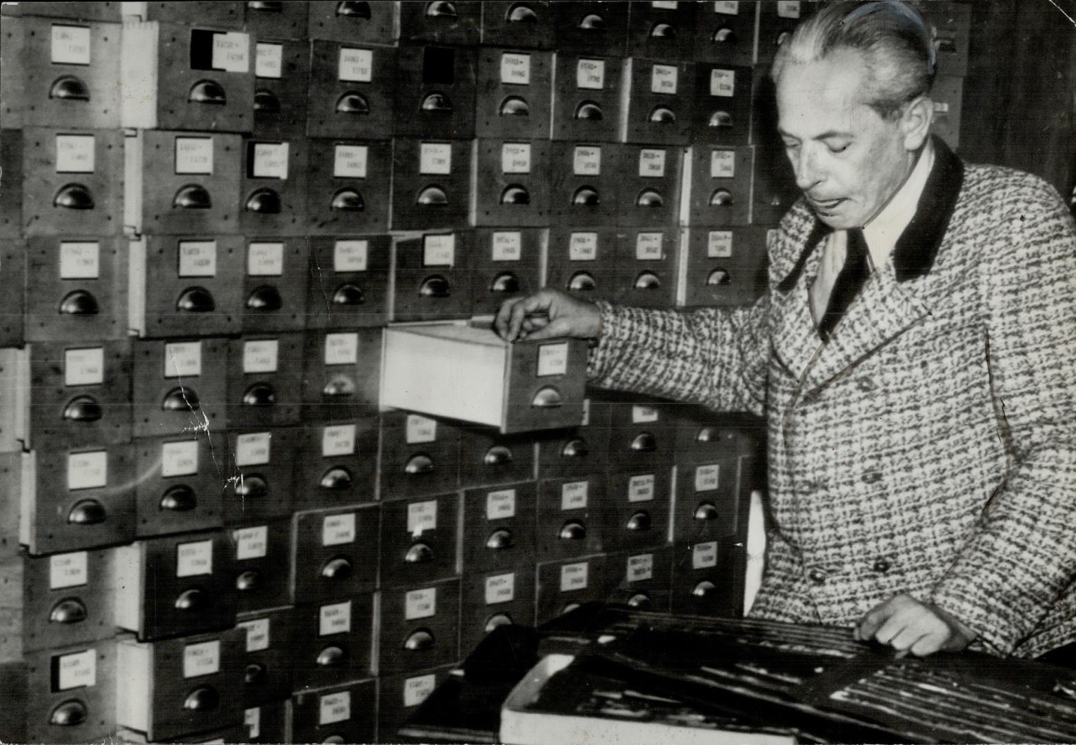 Adolf Hitler's Personal photographer, Heinrich Hoffman, under protective custody of the Allies, is working in the photographic evidence room at Nuremb(...)