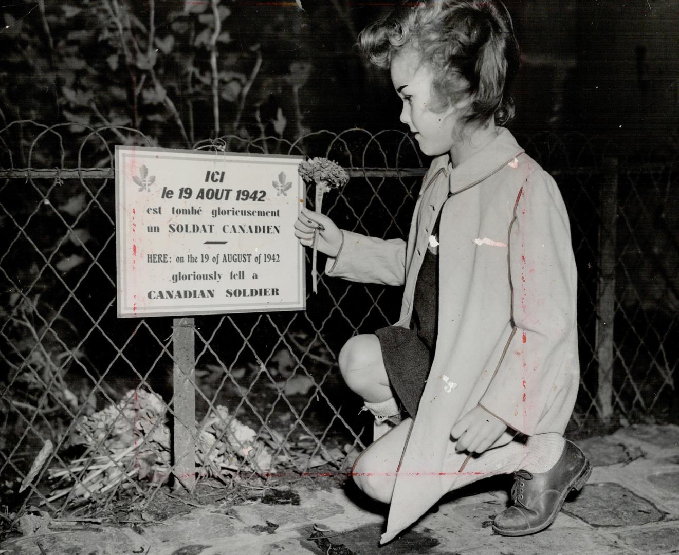 Volle Christiane placing a flower on the spot where one of our men fell at Dieppe, Aug. 19, 1942