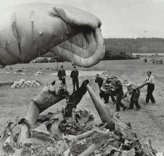 R.a.f. Men work together to pile parts of many flying bombs brought down by large balloon defences