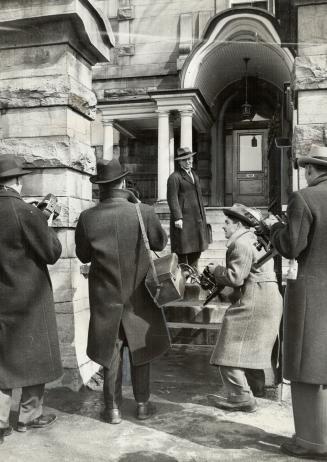 Photographers, after waiting three hours to take shots of four prisoners, were foiled by a police manoeuvre but here they catch H. L. Cartwright, counsel for Capt. Gordon Lunan, one of the suspects