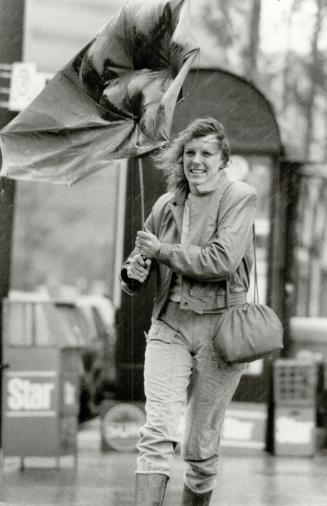 Joanne Lafrance gets a soaking as she battles her way along wind-whipped Bay St