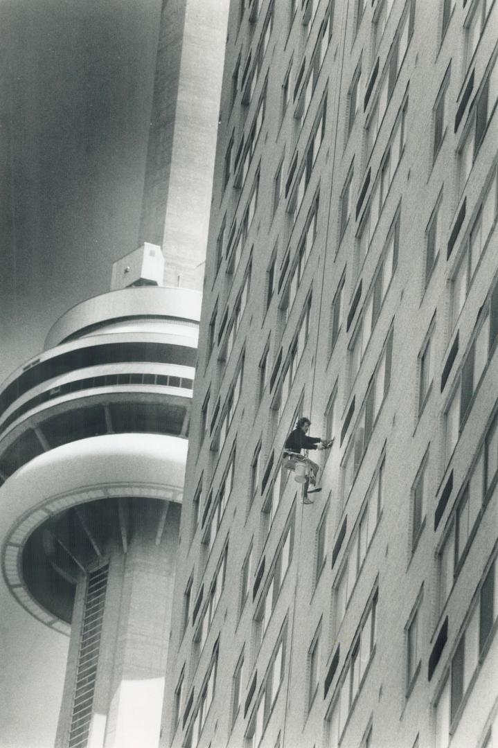 John Martell puts on quite a show for visitors to Harbourfront as he swings on his bosun's chair while cleaning the winter grime from a 28-storey buil(...)