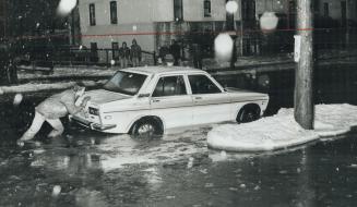 It was slow going for this man as he pushed his car stranded in water flooding Queen St