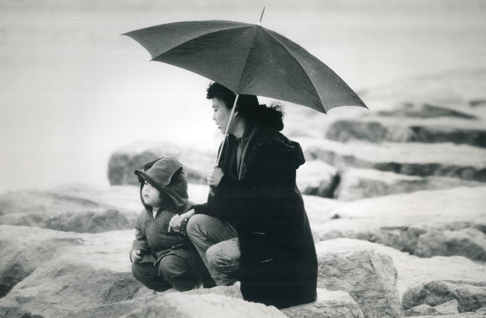 Wet Wonder: Weichieh Lee, 3, enjoys the warm but wet weather yesterday with her mother, Paoling Shen, near Lake Ontario in Port Credit