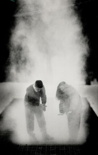 Aaahhhh - warmth, Martin Parr and Jennifer Reece find relief from the deep freeze in warm exhaust from ice rink refrigeration vents at Nathan Phillips Square yesterday