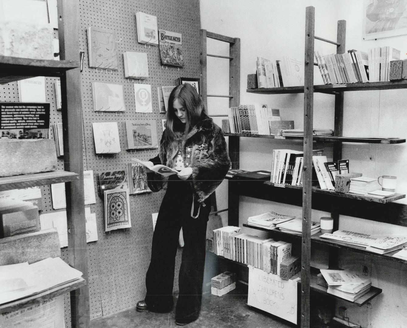 Women's place bookstore attracts interest, Suzanne Evans looks over pamphlets and books, fiction and non fiction