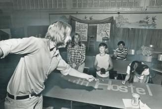 Don Simmons Jr., 19, the son of the Peel County jailer, paints signs for the hostel for hitchhikers he runs in St. Paul's United Church, Brampton, a b(...)