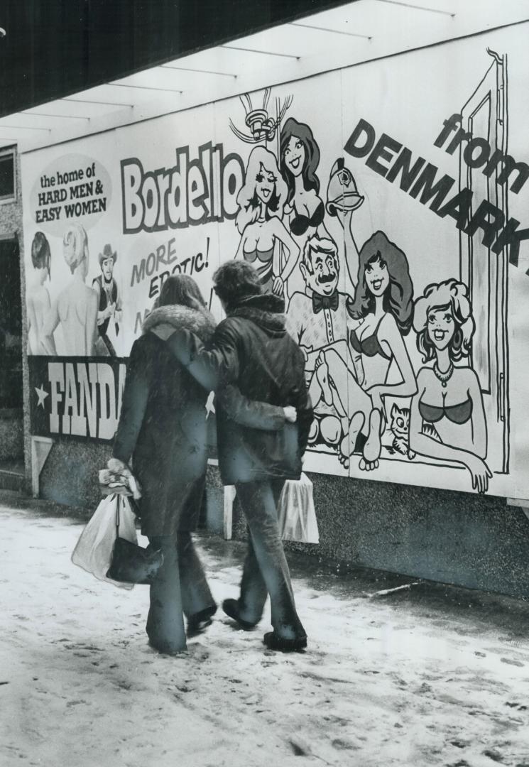 Love's old story has not changed, A young couple with their arms about each other walk past a suggestive movie billboard on Bloor St., above, but thei(...)