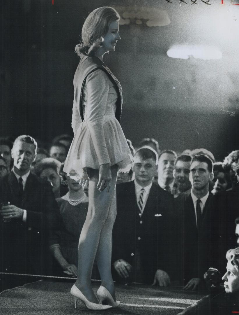 Miss Grey Cup for 1962 flashes winning victory smile, Miss Ottawa Rough Rider, Renata Pikelis, draws approving glances from interested male onlookers