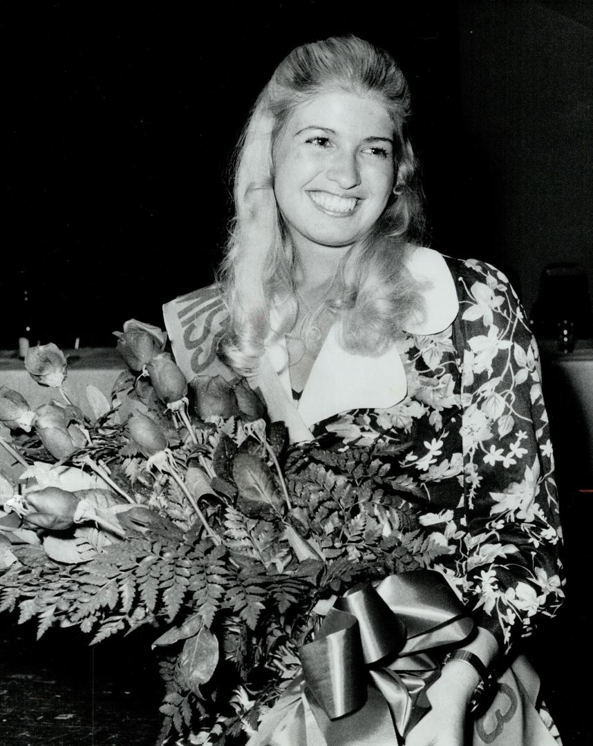 A garland for Miss Argo, Betty Lou Pokol, 20, second-year nursing student at University of Toronto, smiles over her flowers after being chosen Miss Argonaut last night over 17 contestants